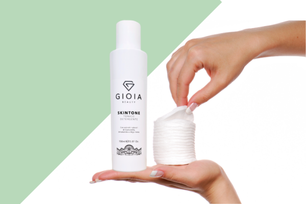 mano con dischetti in cotone e tonico detergente Gioia Beauty